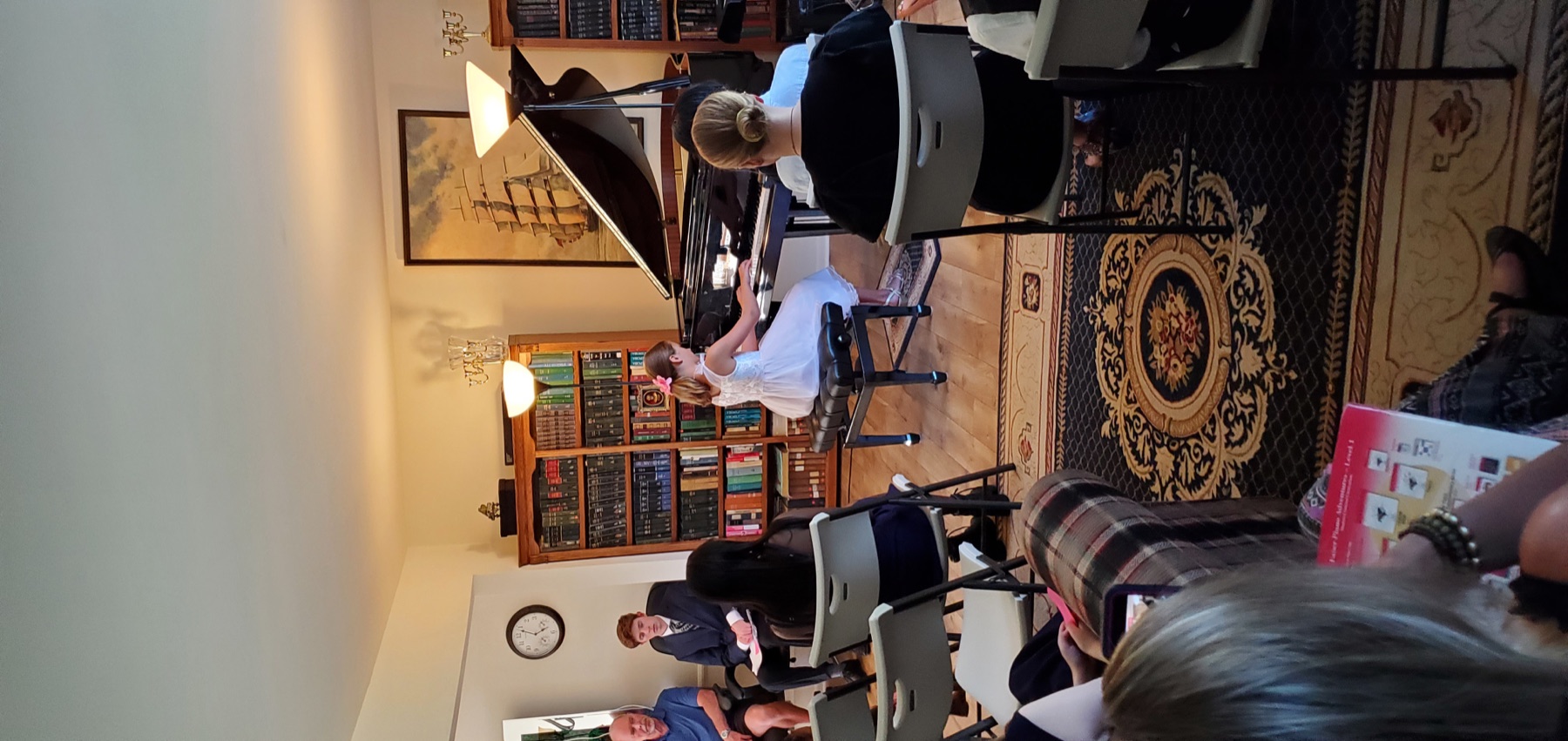 Young student playing the grand piano for an audience